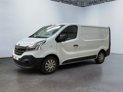 La camionnette blanche est garée à l'intérieur d'une grande pièce blanche.