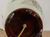 a small vase with a handle on a wooden table
