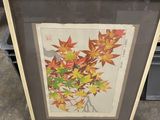 two framed prints of autumn leaves on display in a store