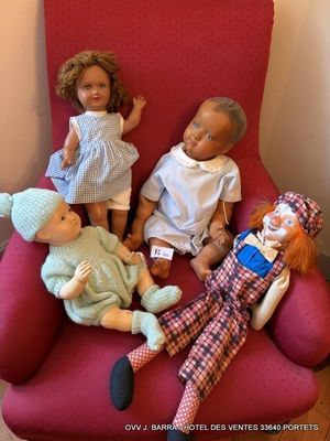 quatre poupées assises sur une chaise rouge dans une pièce