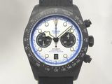 La montre est noire et blanche, avec un cadran bleu.