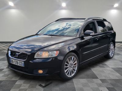une photo d'un break Volvo noir garé sur un sol à damier