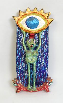 sculpture of a green alien holding a blue eye above its head