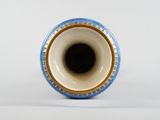 a blue and white vase sitting on a white surface