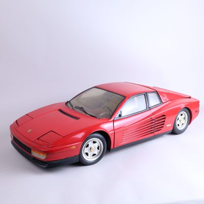 une petite voiture rouge posée sur une surface blanche