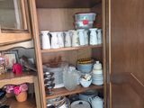 a wooden cabinet with many plates and bowls on it