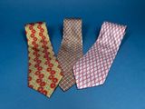 three different colored neck ties on a blue background
