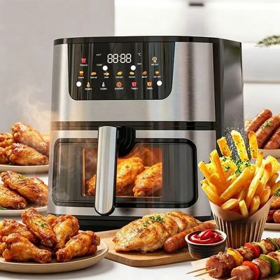 une grande friteuse à air chaud posée sur une table sur laquelle se trouvent de nombreux plats