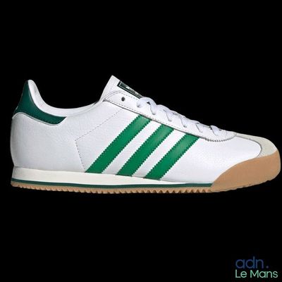 une paire de baskets Adidas blanches et vertes sur fond noir