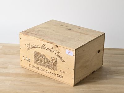 an old wooden box with a label on it sitting on a wooden table