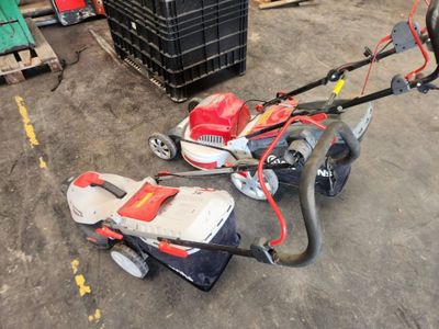 a small lawn mower sitting on the floor in a warehouse