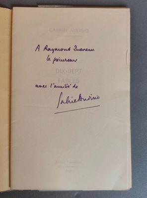 un livre ouvert, sur lequel figure un titre écrit à la main, posé sur une table