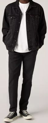 Cet homme porte un t-shirt blanc, un jean noir et une veste en jean noire.