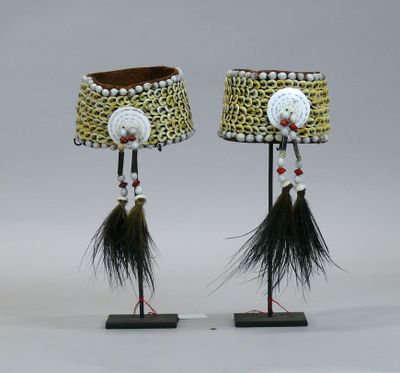 pair of african lamps with feathers and beads on stands