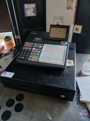 un ordinateur portable posé sur une caisse enregistreuse