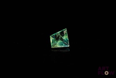 une image représentant un diamant vert dans l'obscurité, sur fond noir