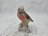 a figurine of a bird sitting on top of a table