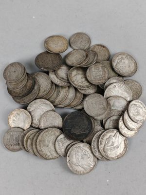 tas de pièces d'argent sur une surface blanche, avec une pièce au milieu