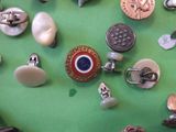 many different types of buttons on a green surface