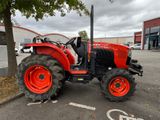 a red tractor that is parked in a parking lot