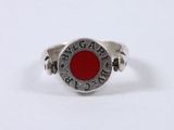 a close up of a silver ring with a red stone