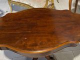 a wooden table with a chair and a chair in the background
