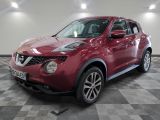 Le SUV Nissan Juke rouge est garé dans une grande pièce.