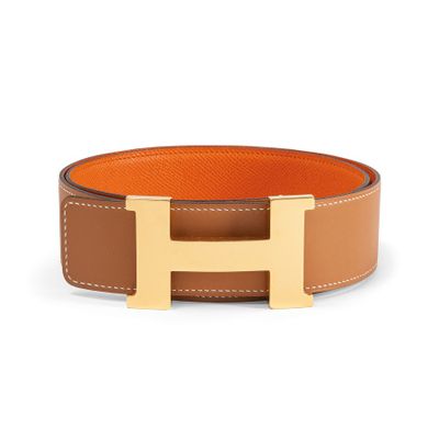 a brown and tan leather belt with a gold h buckle