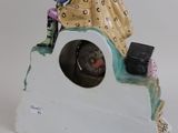 a figurine of a woman sitting on top of a clock