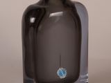 a black glass bottle with a blue design on it