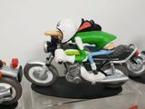 three figurines of a man riding a motorcycle on display