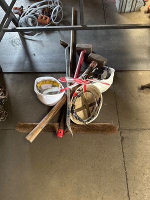 a pile of tools sitting on the floor next to a table