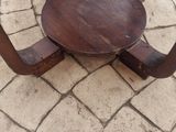 a small table with a wooden top on a brick floor