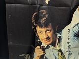 a poster of a man holding a gun in front of a stop sign