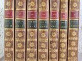 six vieux livres sont alignés sur une table