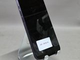 un téléphone portable posé sur un support sur une table