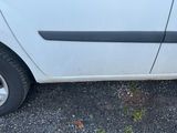 une petite voiture blanche garée sur le bord de la route