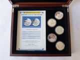 a wooden box with four coins in it and a certificate