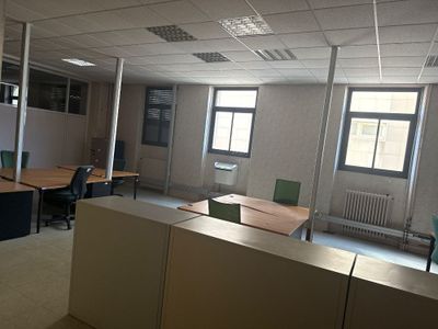 une pièce équipée d'un bureau, de chaises et d'un écran