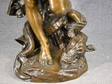 bronze statue of a woman with a dog on a rock