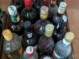 de nombreuses bouteilles d'alcool posées dans une boîte par terre