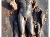 a statue of a man holding a bull on a wall