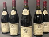 six bouteilles de vin sont alignées sur une table