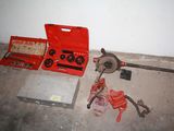 a red tool box sitting on the floor next to tools