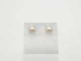 une paire de boucles d'oreilles en perles posée sur un support en acrylique transparent