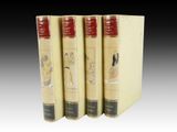 three books are lined up in a row on a white surface