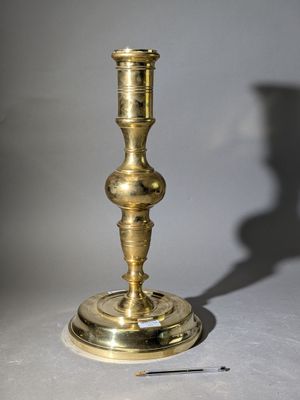une bougie posée sur une table à côté d'une aiguille