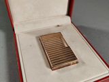 un petit étui à cigarettes en or dans une boîte rouge