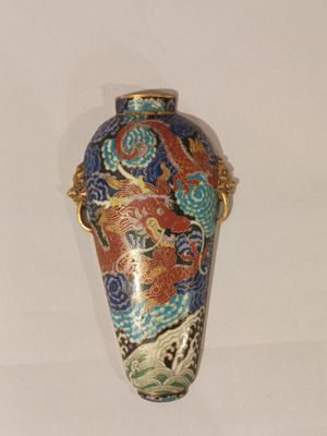 un vase orné d'un dragon posé sur une table