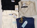 Trois paires de pantalons pour homme et un t-shirt sont posés sur une table